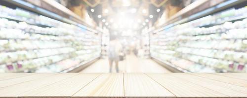 Wood table top with supermarket grocery store blurred background with bokeh light for product display photo