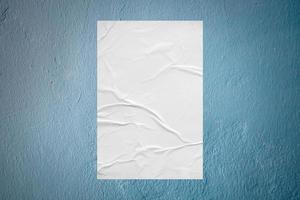 Blank white wheatpaste glued paper poster mockup on concrete wall background photo