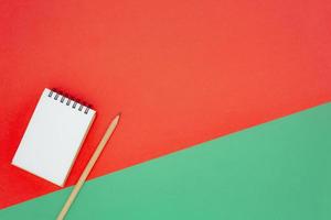 Christmas or holiday concept. White blank mini spiral notepad and wooden pencil. photo