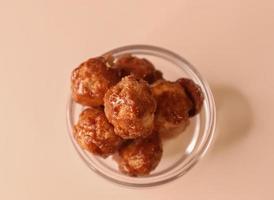 Selective focus of many candied macadamia nuts spinning in a small bowl. photo