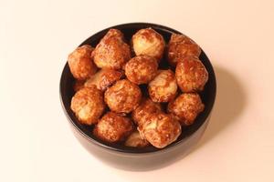 Selective focus of many candied macadamia nuts spinning in a small bowl. photo