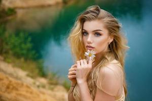 portrait of a beautiful girl with a Daisy in her hands, beautiful make-up photo