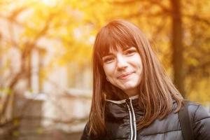 Portrait of a cute young woman in autumn on a Sunny day photo