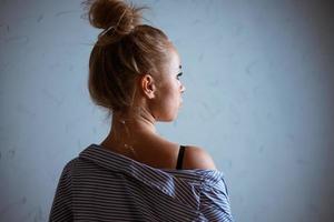 Portrait of a woman against the background of a gray wall photo