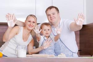 Father mother and son at home stand at the table in the kitchen together photo