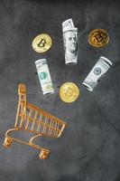 Dollar bills and itkon coins flew out of the Golden Basket on a dark background. photo