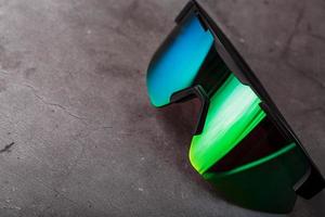 Green sports glasses with a mirror lens on a dark background photo