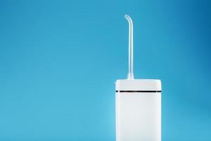 White oral irrigator on a blue background. photo
