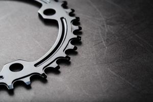 A black bicycle driving star with contrasting repeating cogs on a dark background photo