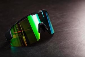 Green sports glasses with a mirror lens on a dark background photo