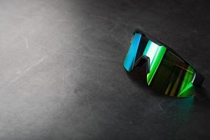 Green sports glasses with a mirror lens on a dark background photo