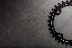 A black bicycle driving star with contrasting repeating cogs on a dark background photo