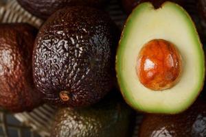 Chopped pitted and whole organic Hass avocado close-up. photo