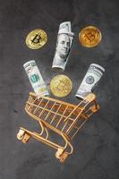 Dollar bills and itkon coins flew out of the Golden Basket on a dark background. photo