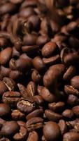 vertikal långsam rörelse av rostad kaffe bönor faller. organisk kaffe frön. video