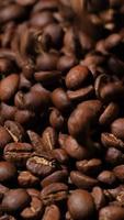 Vertical slow motion of roasted coffee beans falling. Organic coffee seeds. video