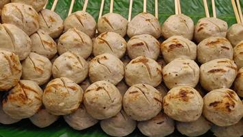 Big grilled pork meatballs sale at the market, Thai street food. Easy to find. video
