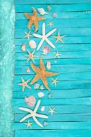 cubiertas de mar azul de madera, tablas con estrellas de mar naranjas y blancas, conchas marinas cerca de la piscina. concepto de vacaciones, turismo, verano. copie el espacio foto