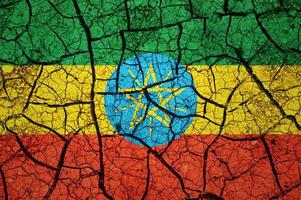 Dry soil pattern on the flag of Ethiopia. Country with drought concept. Water problem. Dry cracked earth country. photo