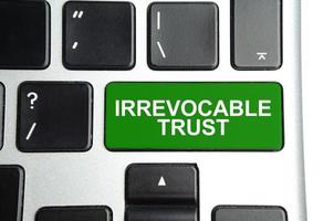 Irrevocable trust text on green button keyboard photo