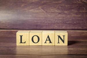 LOAN concept with wooden block on wooden table background. photo