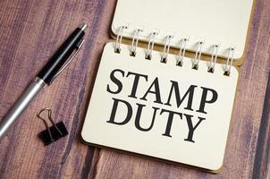 The word stamp duty written on a wooden background photo