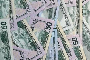 Many one hundred and fifty dollar bills on flat background surface close up. Flat lay top view photo