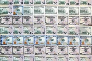 Many one hundred and fifty dollar bills on flat background surface close up. Flat lay top view photo