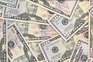 Many US fifty dollar bills on flat background surface close up. Flat lay top view. Abstract business concept photo