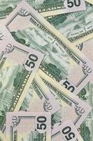 Many US fifty dollar bills on flat background surface close up. Flat lay top view. Abstract business concept photo