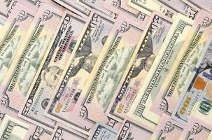 Many one hundred and fifty dollar bills on flat background surface close up. Flat lay top view photo