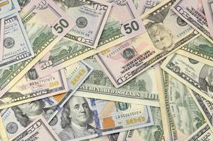 Many one hundred and fifty dollar bills on flat background surface close up. Flat lay top view photo