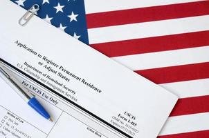 I-485 Application to register permanent residence or adjust status blank form lies on United States flag with blue pen from Department of Homeland Security photo