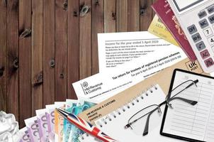 English Tax form sa970 Tax return for trustees of registered pension schemes from HM revenue and customs lies on table with office items. HMRC paperwork and tax paying process photo