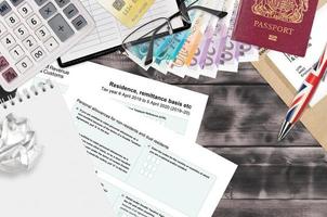 formulario de impuestos en inglés sa108 base de remesa de residencia, etc. de ingresos y aduanas de hm se encuentra en la mesa con artículos de oficina. trámites de hmrc y proceso de pago de impuestos en reino unido foto