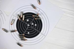 Many bullets on shooting targets on white table in shooting range polygon. Training for aiming and shooting photo