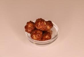 Selective focus of many candied macadamia nuts spinning in a small bowl. photo