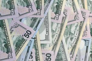 Many one hundred and fifty dollar bills on flat background surface close up. Flat lay top view photo
