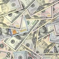 Many one hundred and fifty dollar bills on flat background surface close up. Flat lay top view photo