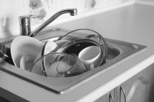 Dirty dishes and unwashed kitchen appliances filled kitchen sink photo