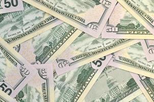Many US fifty dollar bills on flat background surface close up. Flat lay top view. Abstract business concept photo