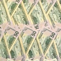 Many one hundred and fifty dollar bills on flat background surface close up. Flat lay top view photo