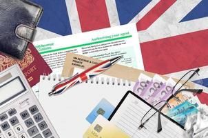 English form 64-8 Authorising your agent from HM revenue and customs lies on table with office items. HMRC paperwork and tax paying process in United Kingdom photo