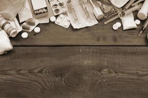 A lot of narcotic substances and devices for the preparation of drugs lie on an old wooden table photo