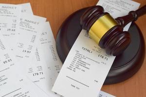 Justice mallet and many supermarket receipts on wooden table