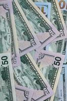 Many one hundred and fifty dollar bills on flat background surface close up. Flat lay top view photo