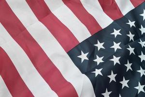 Image of a crumpled American flag with many folds waving in the wind photo