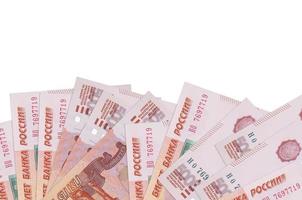 Los billetes de 5000 rublos rusos se encuentran en la parte inferior de la pantalla aislados en fondo blanco con espacio de copia. plantilla de banner de fondo foto