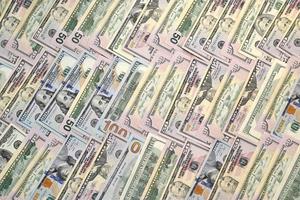 Many one hundred and fifty dollar bills on flat background surface close up. Flat lay top view photo