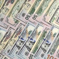 Many one hundred and fifty dollar bills on flat background surface close up. Flat lay top view photo